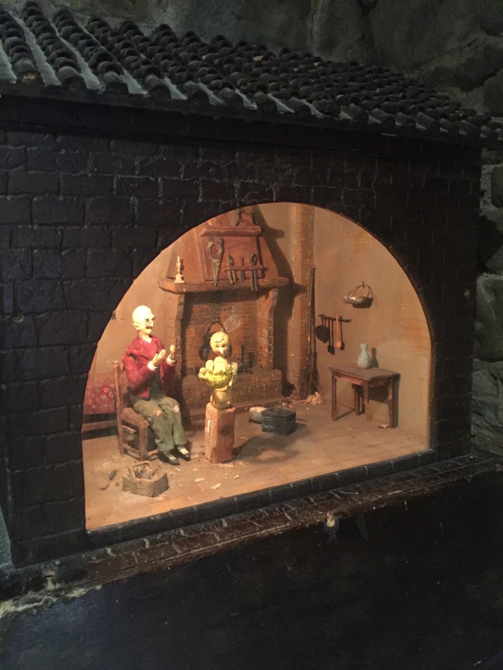 Geppetto e Pinocchio si muovono dentro la teca di legno